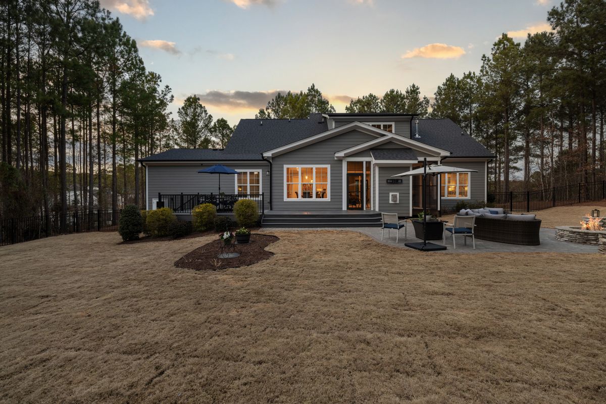 A low house with lit windows and a wide rear garden at dusk — photo by Curtis Adams on Pexels