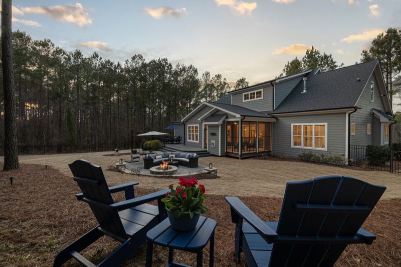 Backyard seating and fire pit behind a house at sunset, photo by Curtis Adams on Pexels