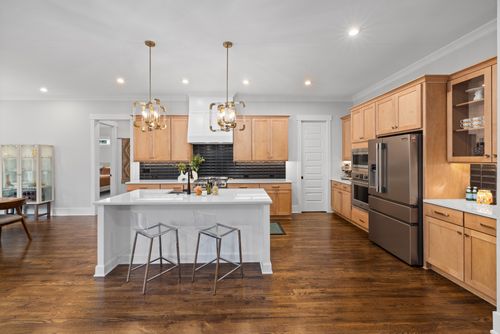 Free Bright, spacious kitchen featuring wooden cabinets, island, and stainless steel appliances. Stock Photo