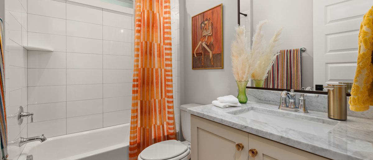 Shower curtain rod being mounted on tile in a DMV bathroom