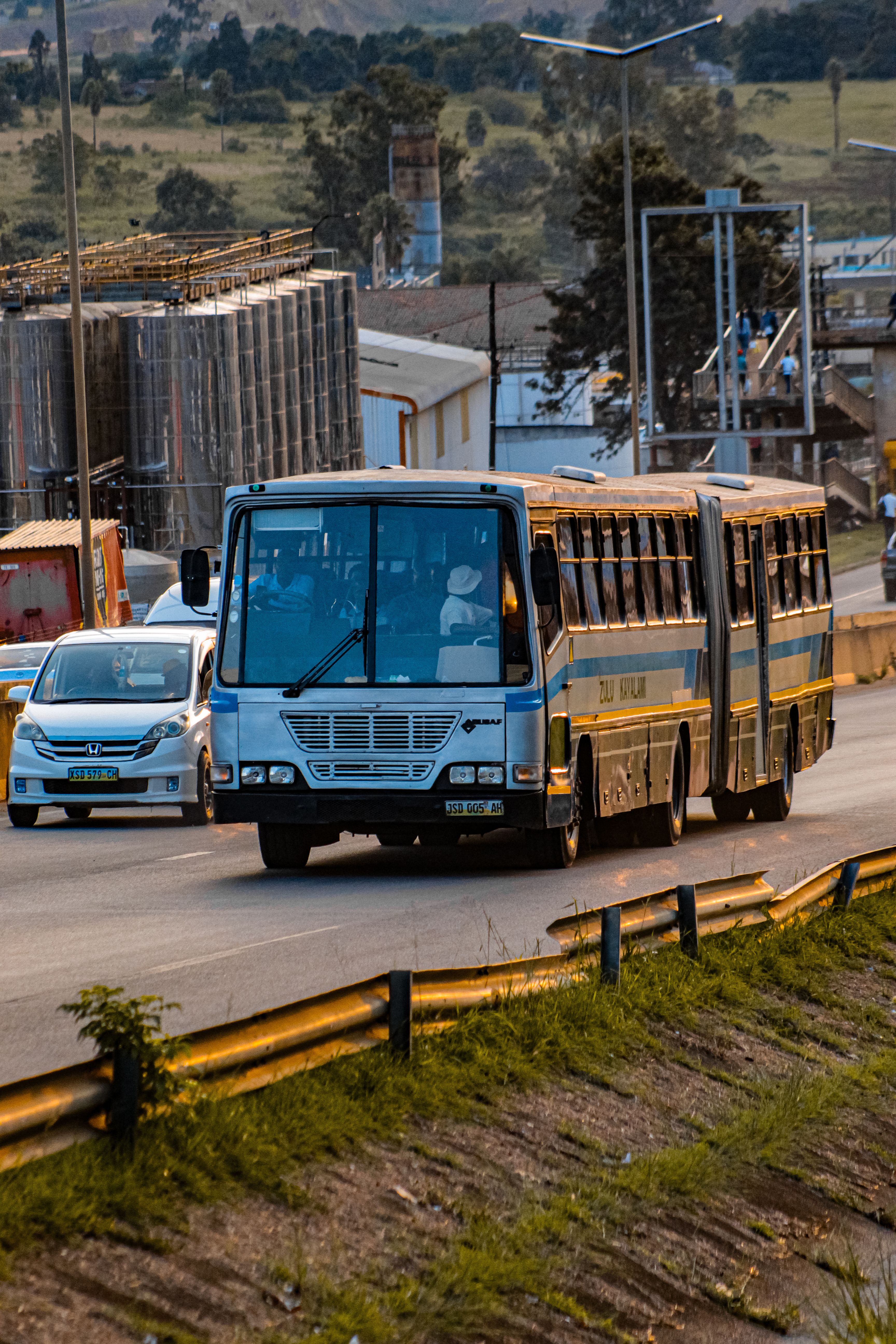 A public bus and cars travel on the highway in Matsapha, showcasing daily commuting in Eswatini.
