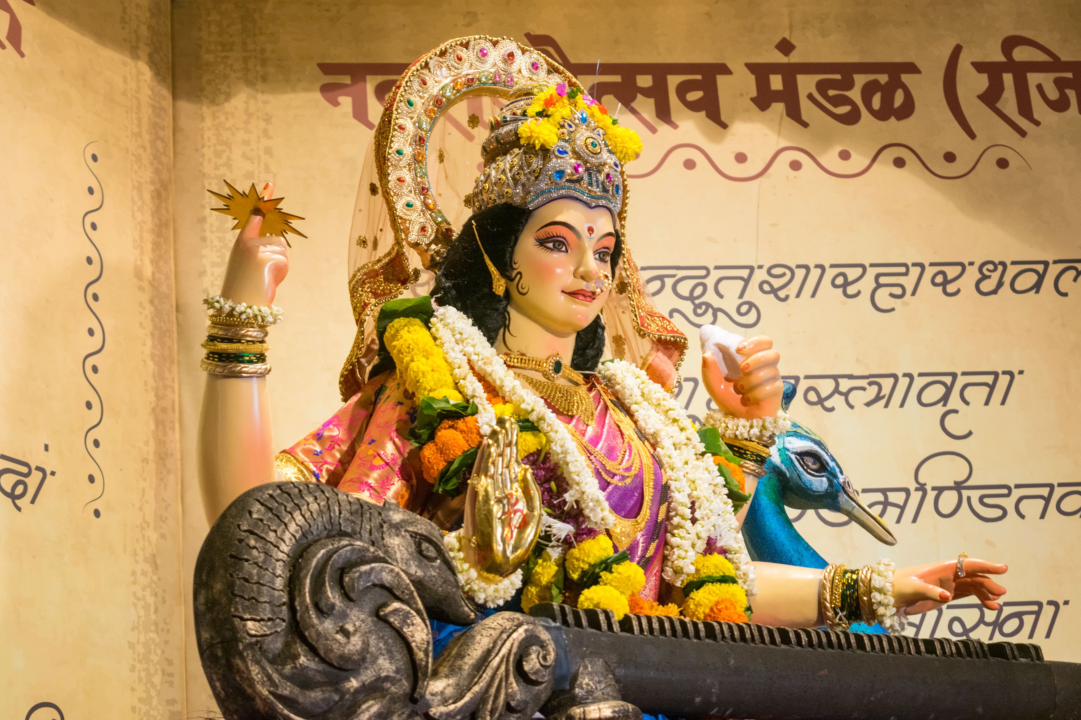 Colorful statue of a Hindu goddess adorned with flowers during Navratri in Mumbai, India.