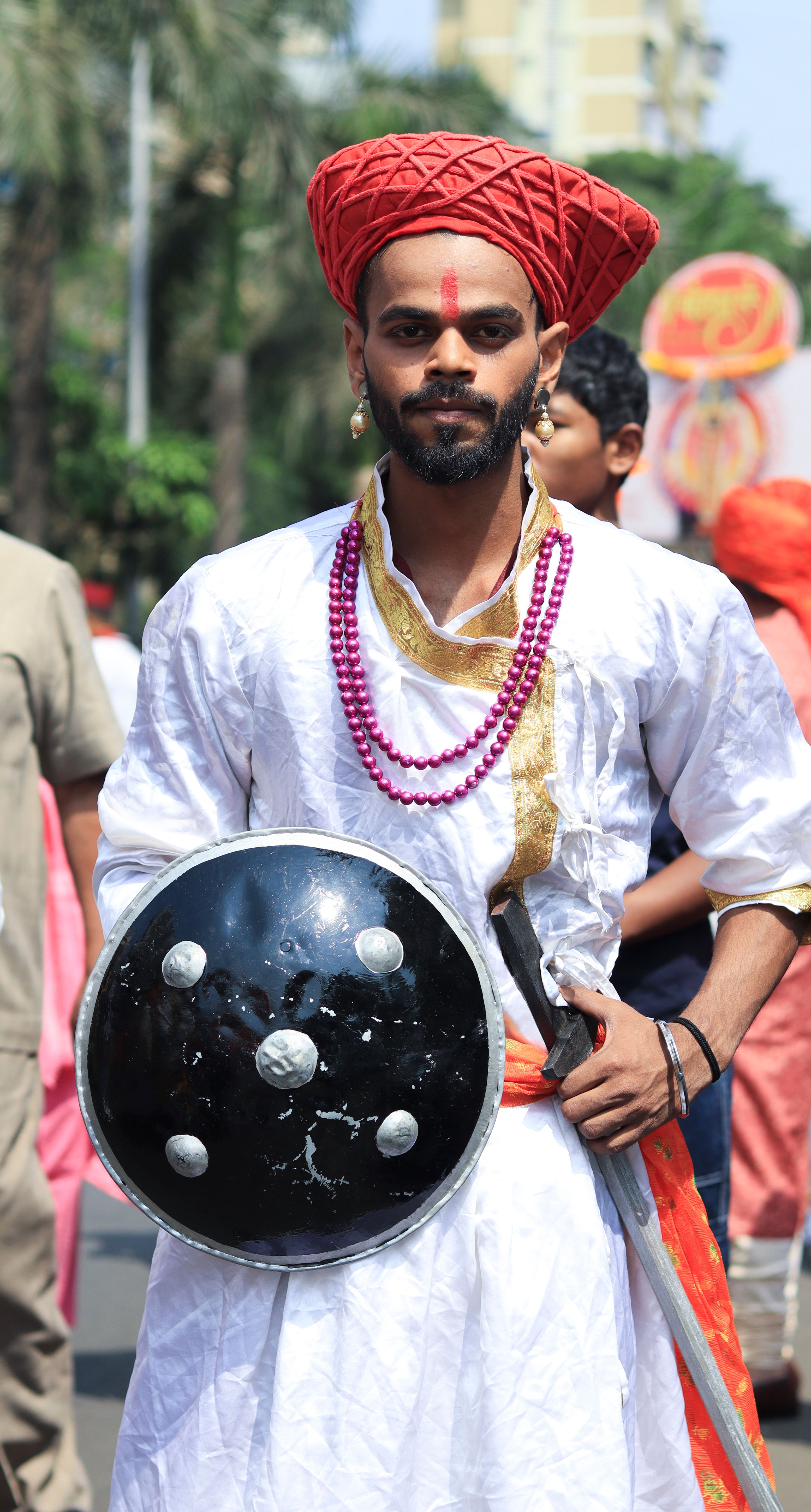 A Maratha warrior in traditional attire with a shield and sword at a cultural festival in Mumbai, India.