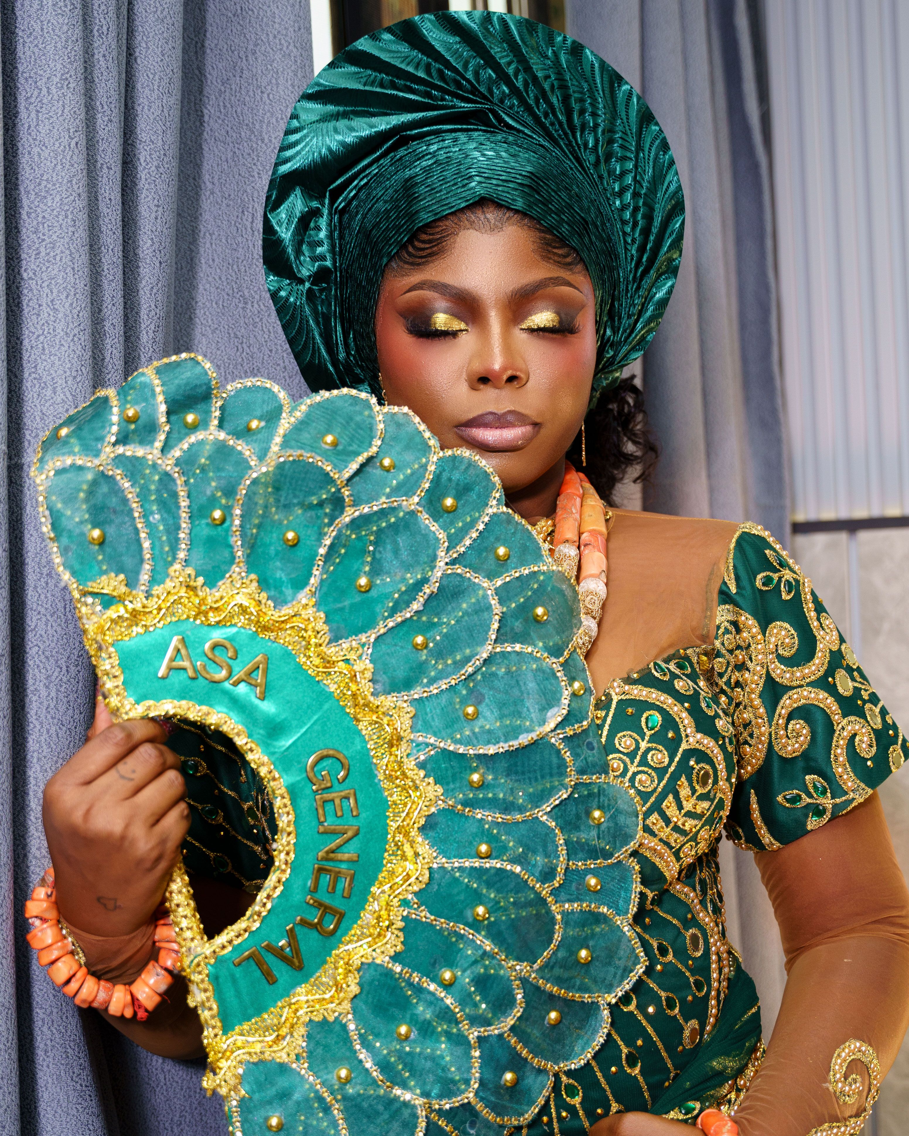 Portrait of a woman in vibrant African traditional dress with a detailed fan.