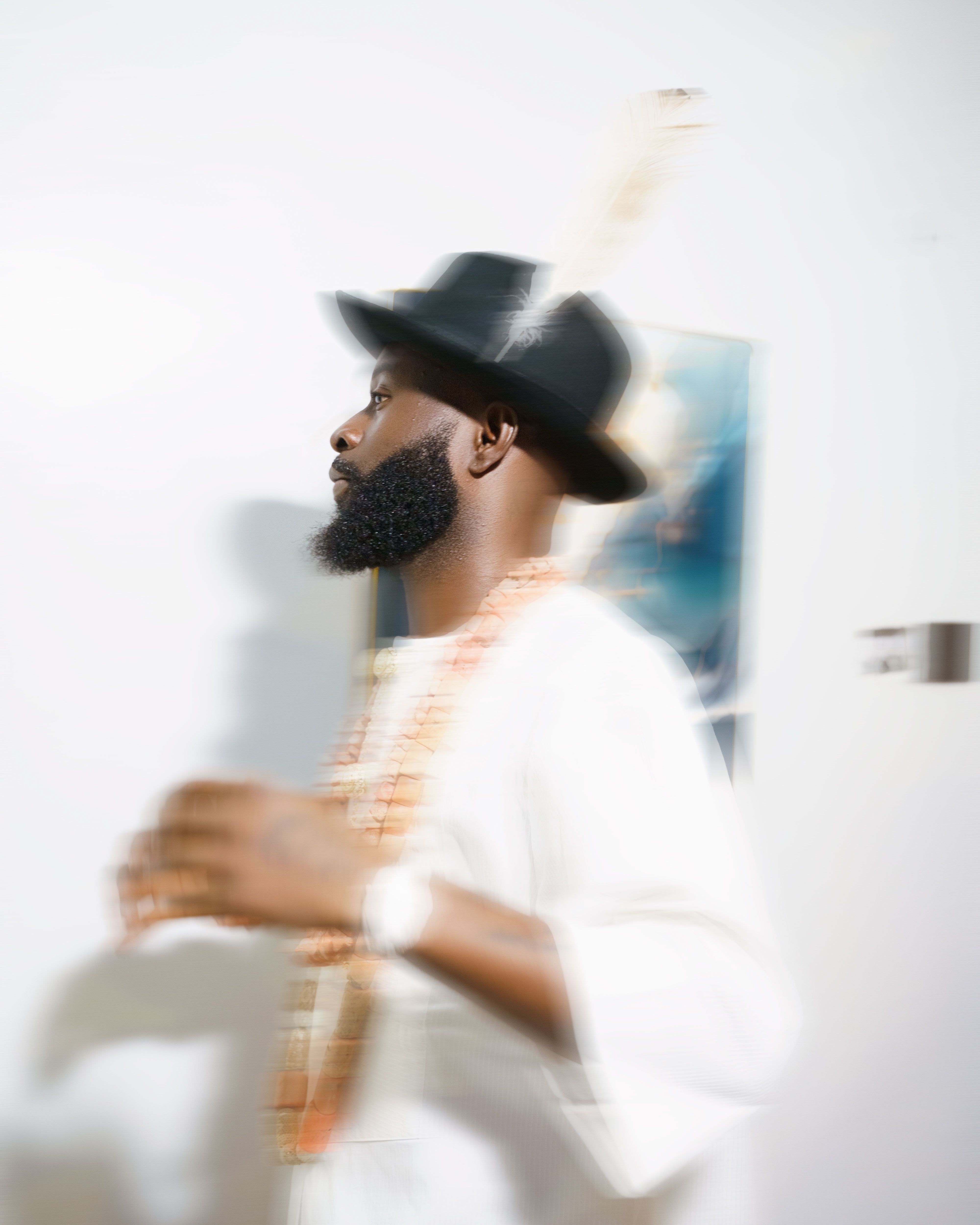 Blurred image of a man in traditional attire with a classic hat, minimalistic style.