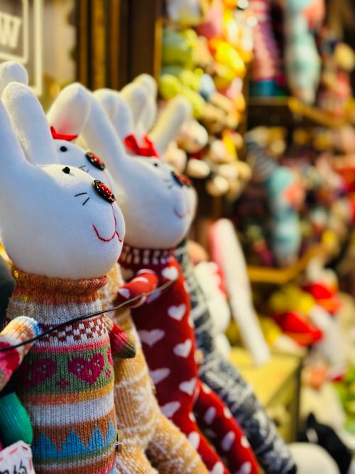 Free Charming knitted bunny toys in colorful sweaters on a festive display. Ideal for holiday decor. Stock Photo