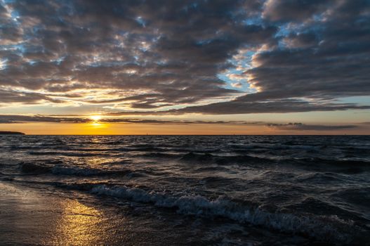 Ocean sunset with dramatic clouds creating a serene and picturesque seascape.