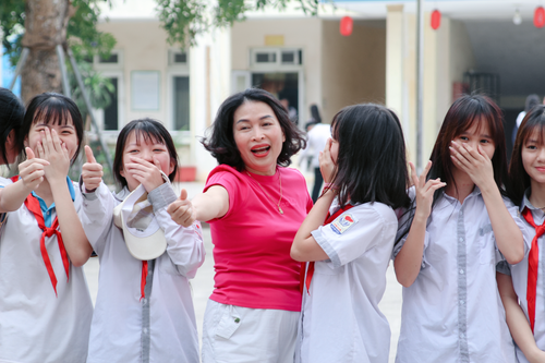 Free A joyful group of students with their teacher smiling outdoors, promoting education and camaraderie. Stock Photo