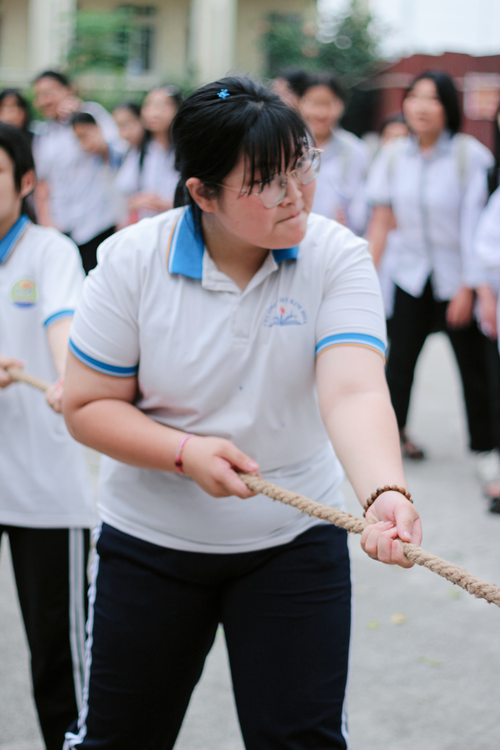 Free A group of students enthusiastically participating in a tug-of-war competition outdoors. Stock Photo