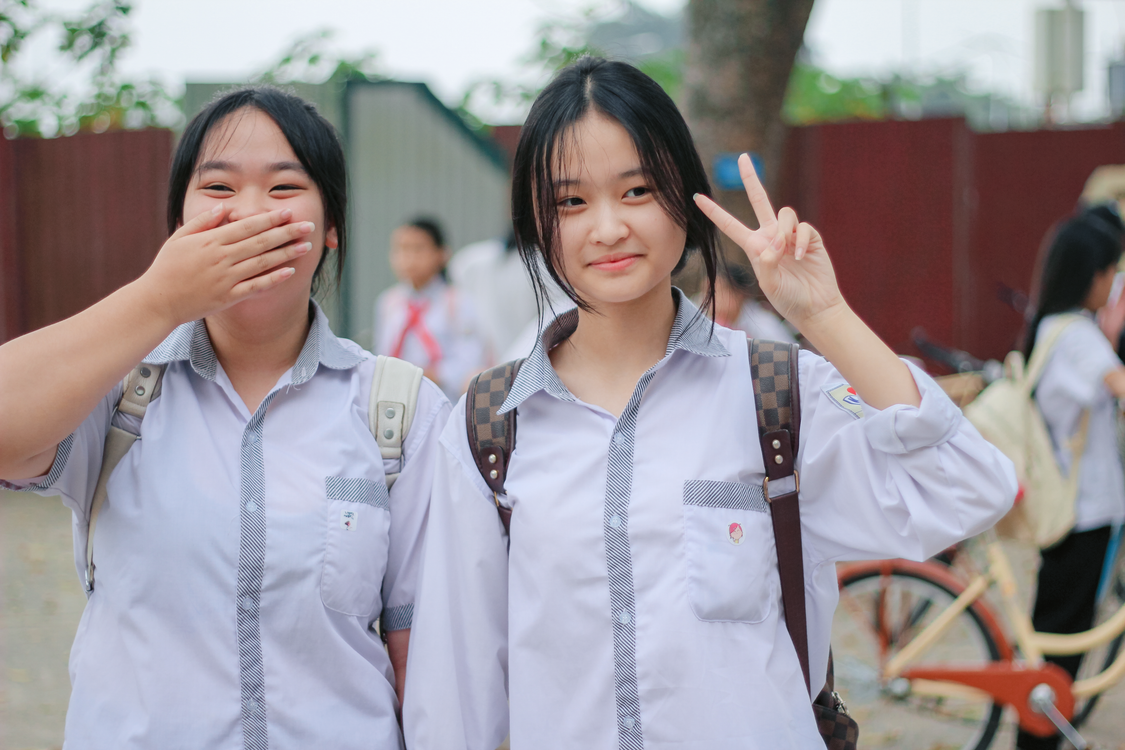 Happy School Girls Posing Outdoors in Uniforms · Free Stock Photo