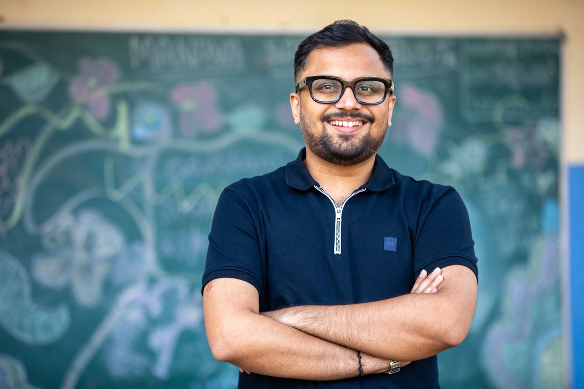 An educator at a chalkboard, mid-explanation.