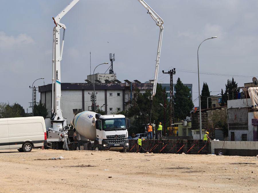 Concrete mixer trucks and workers at a site