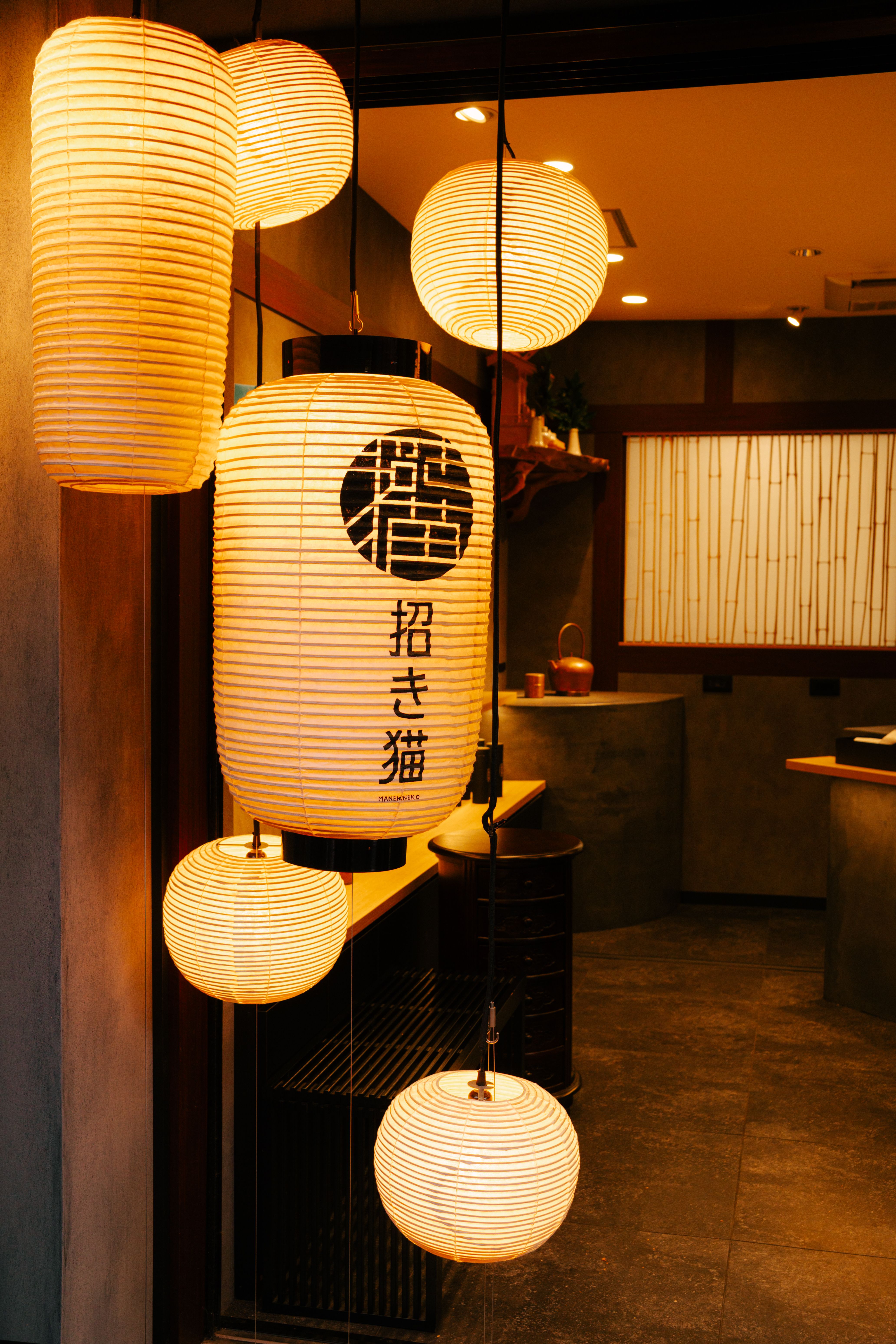 Warm glow of Japanese paper lanterns in a cozy Tokyo shop entrance.