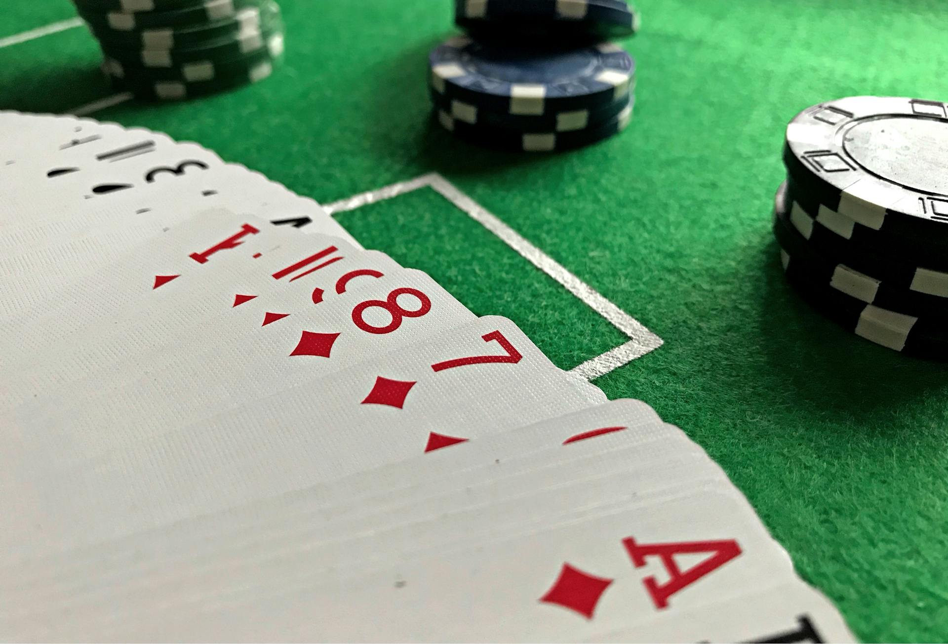 Close-up view of poker cards and chips on a green felt table, perfect for casino-themed content.