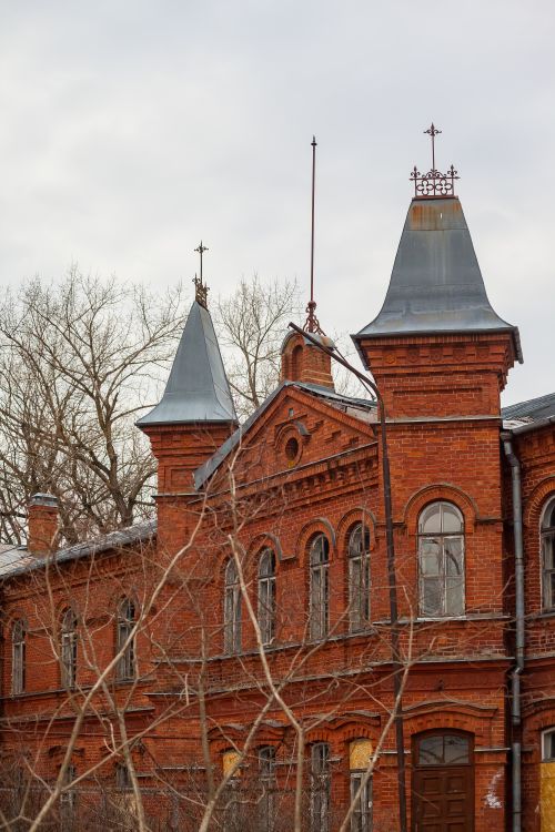 Free A picturesque historic red brick building featuring unique architectural steeples and intricate designs. Stock Photo