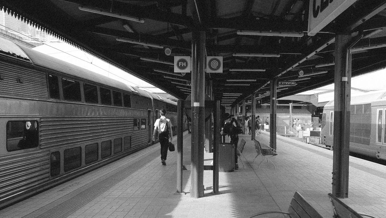 Grayscale Photo of People Walking on Train Station