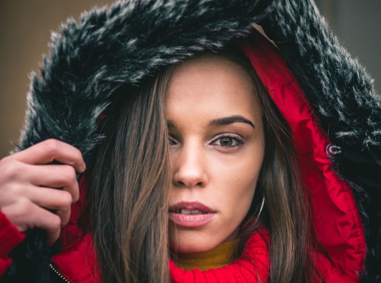 Close-up of a woman in a red coat with a faux-fur hood