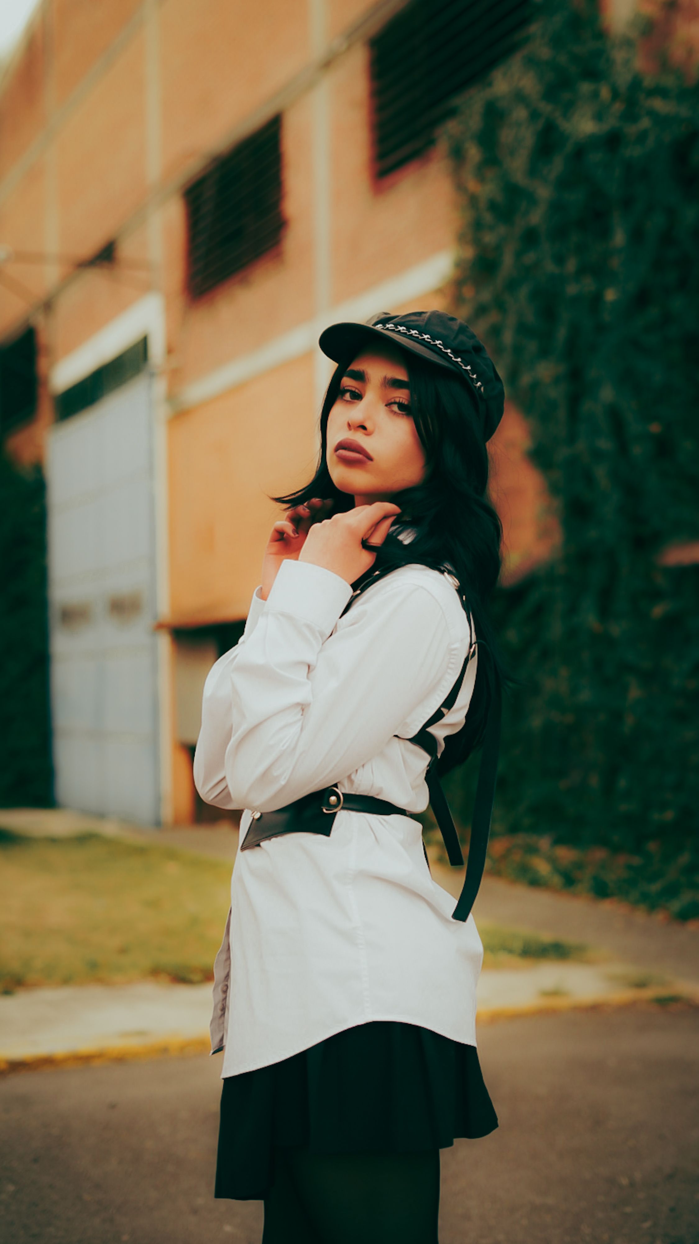 Mulher elegante posa em ambiente urbano, exibindo um estilo de rua moderno.
