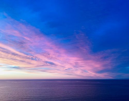 Free Stunning ocean sunset with vivid pink and blue sky hues over calm waters. Stock Photo