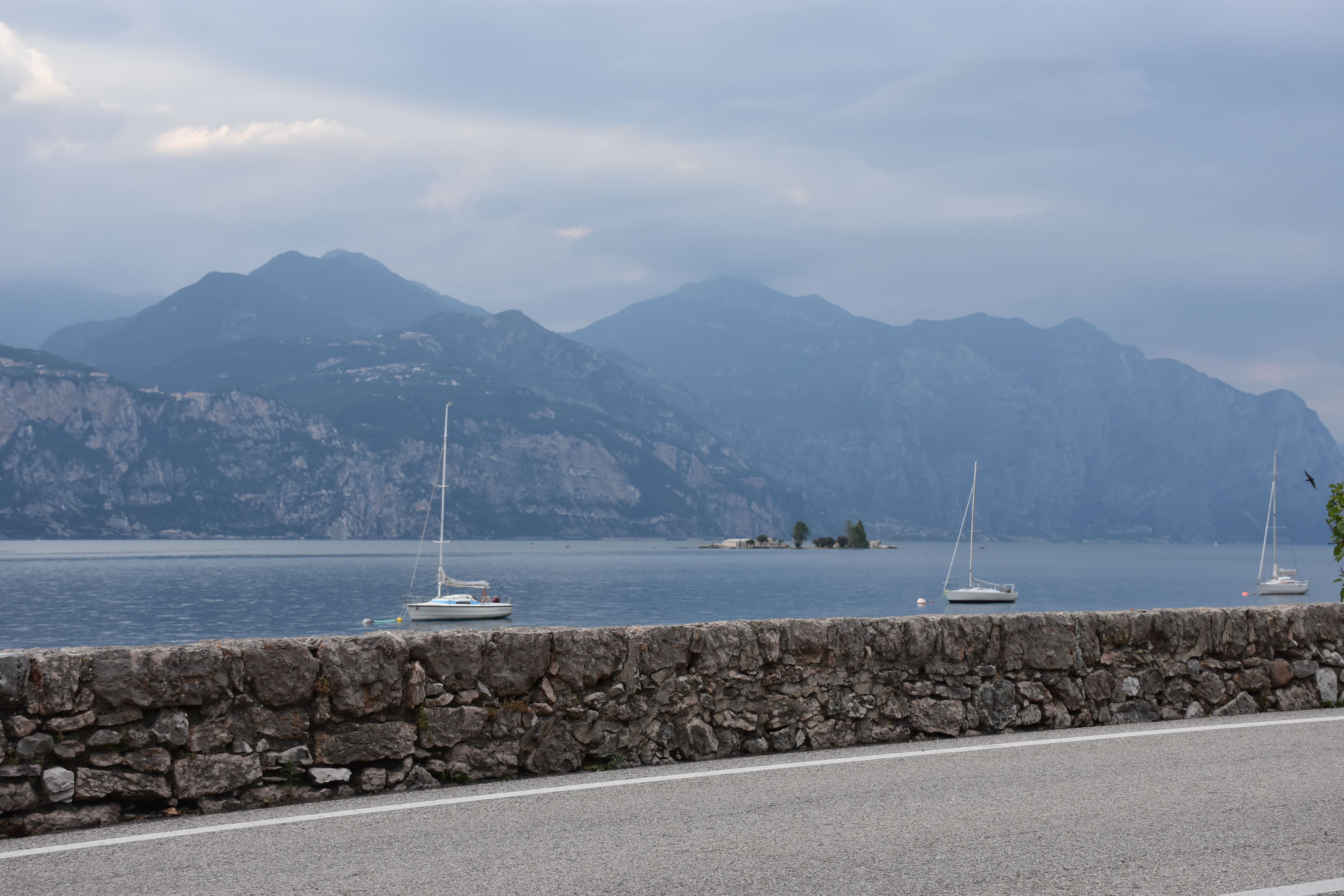 Scenic view of Lake Garda with sailing boats and mountains in the background.