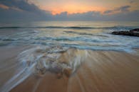 用长时间曝光拍摄了日出时海浪轻抚沙滩的宁静画面