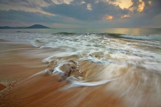 Peaceful seascape of waves and clouds at sunset, perfect for calming visuals.