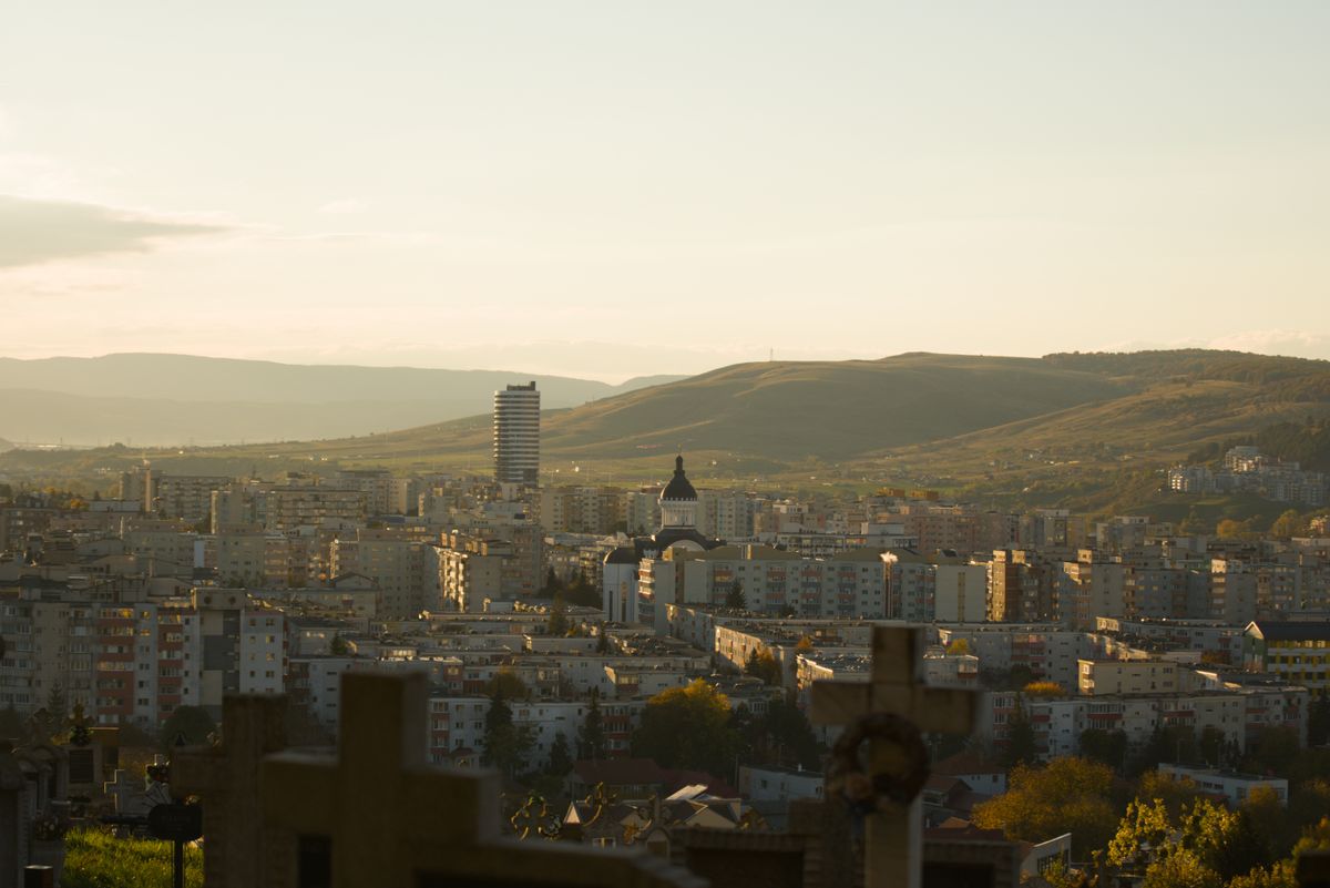 Cluj-Napoca - panoramă a orașului cu dealuri la apus