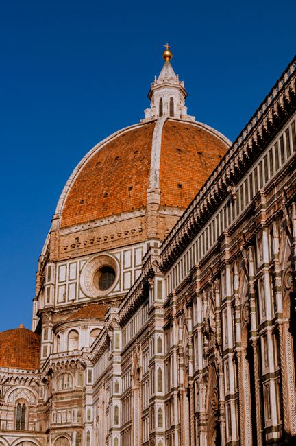 Elegant view of Florence's iconic Duomo Brunelleschi dome under blue sky, highlighting Renaissance architecture.