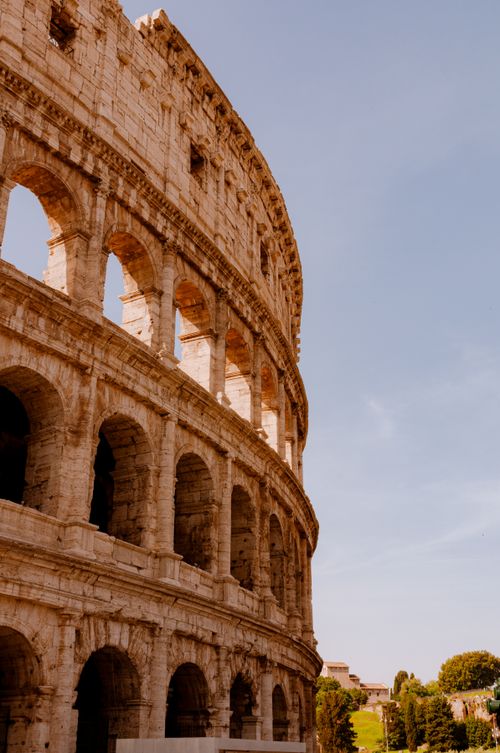 Free The majestic Colosseum in Rome under a clear blue sky, showcasing its ancient architecture. Stock Photo