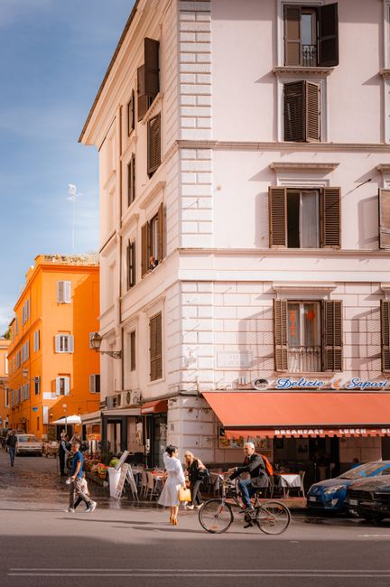 Bustling street corner in Rome's Trastevere with vibrant buildings and pedestrians.