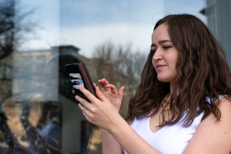Photo by Andrew Patrick Photo on Pexels Young woman in a white dress using her smartphone outdoors. Bright day with reflections in a window.