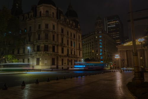 Free A nocturnal cityscape showcasing elegant historic buildings with light trails from moving vehicles. Stock Photo