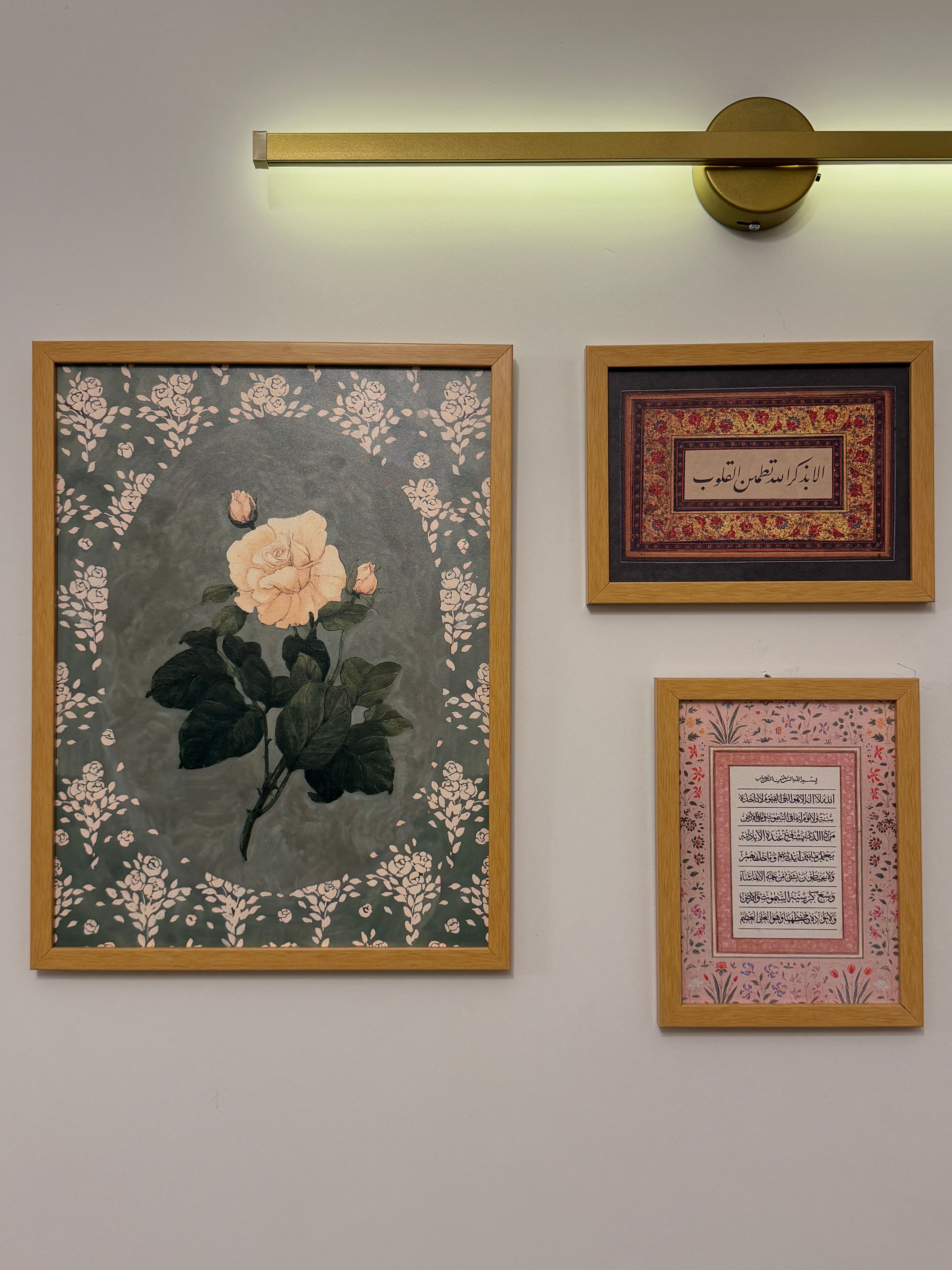 Aesthetic wall art featuring floral and calligraphy pieces under warm lighting.