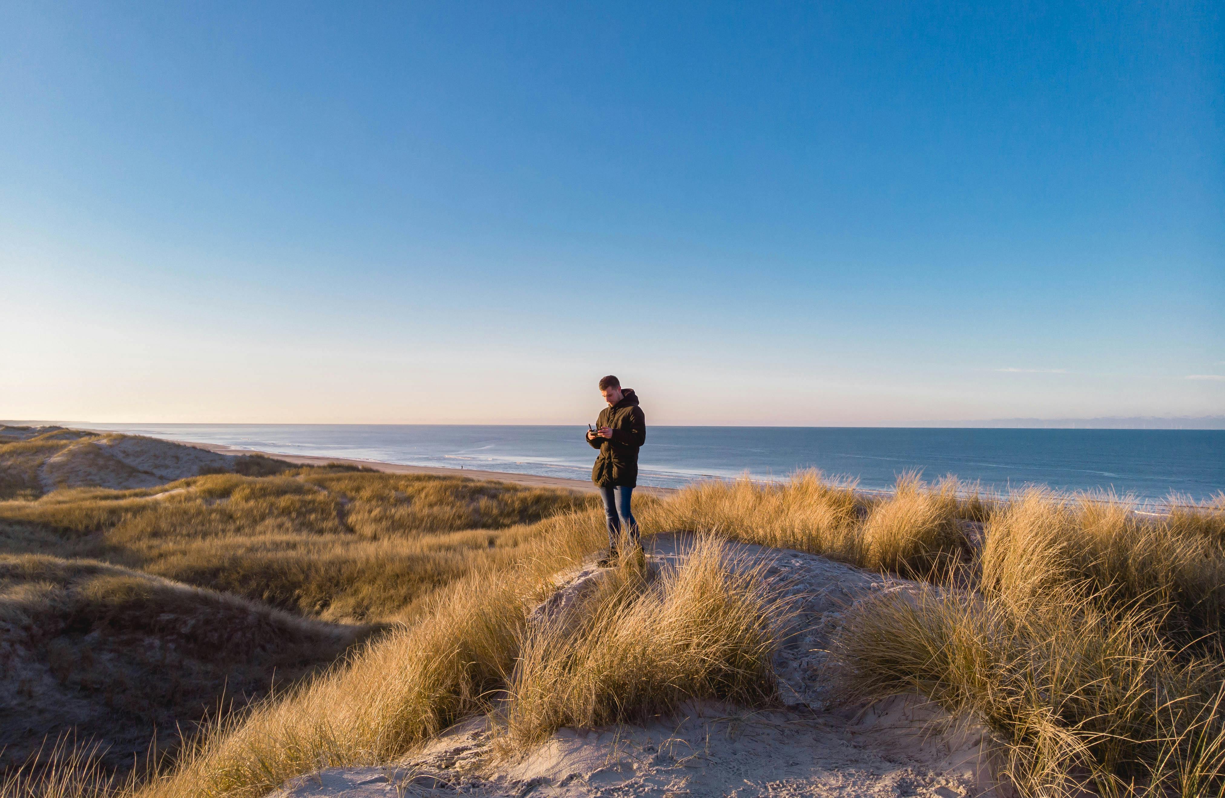 A man enjoys a peaceful scenic view on the dunes of Henne Kirkeby, Denmark at daytime.