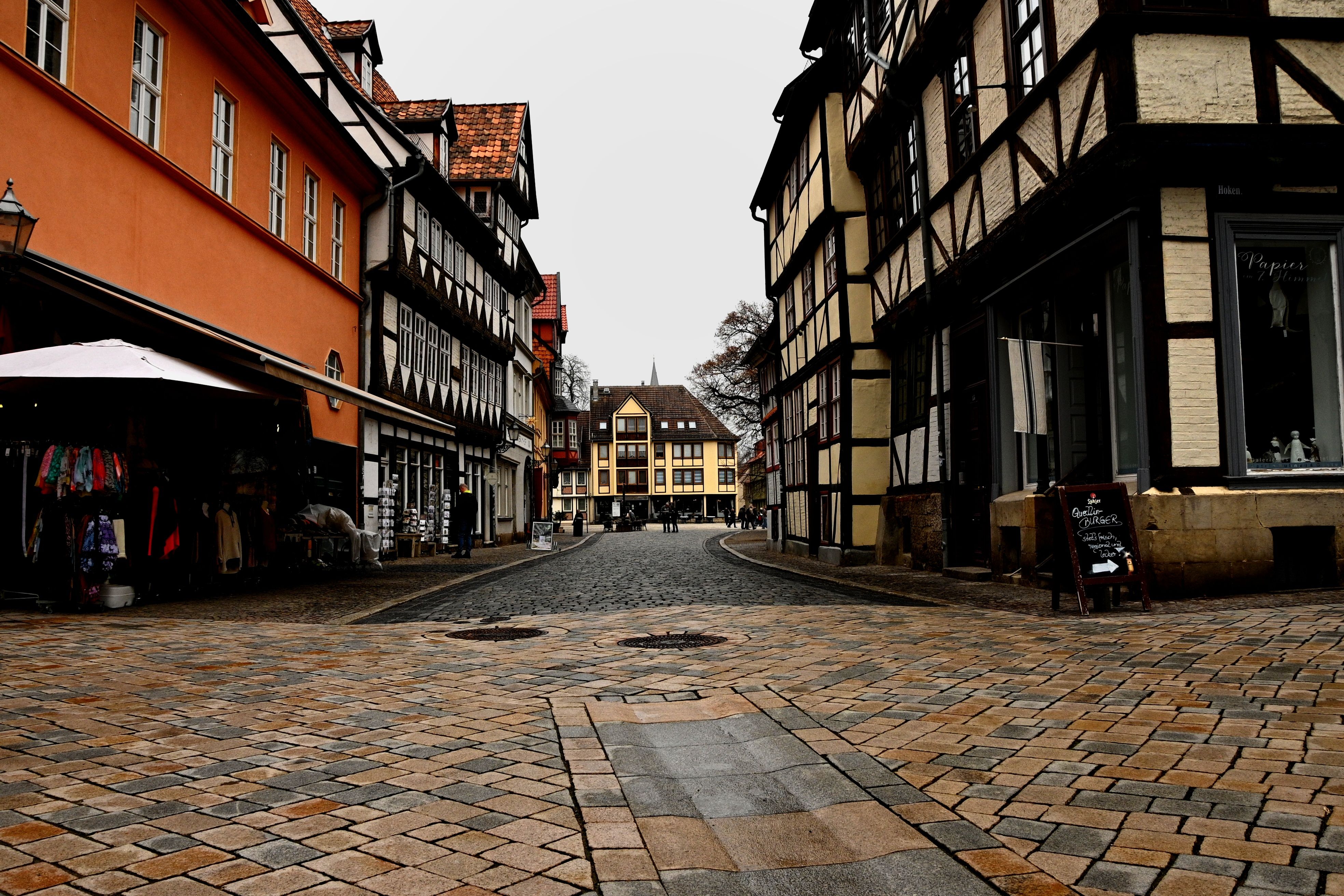 Historic European street with half-timbered houses under an overcast sky, capturing old-world charm.