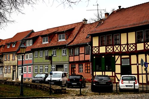 Free Traditional half-timbered houses in a European town, with parked cars and overcast sky. Stock Photo