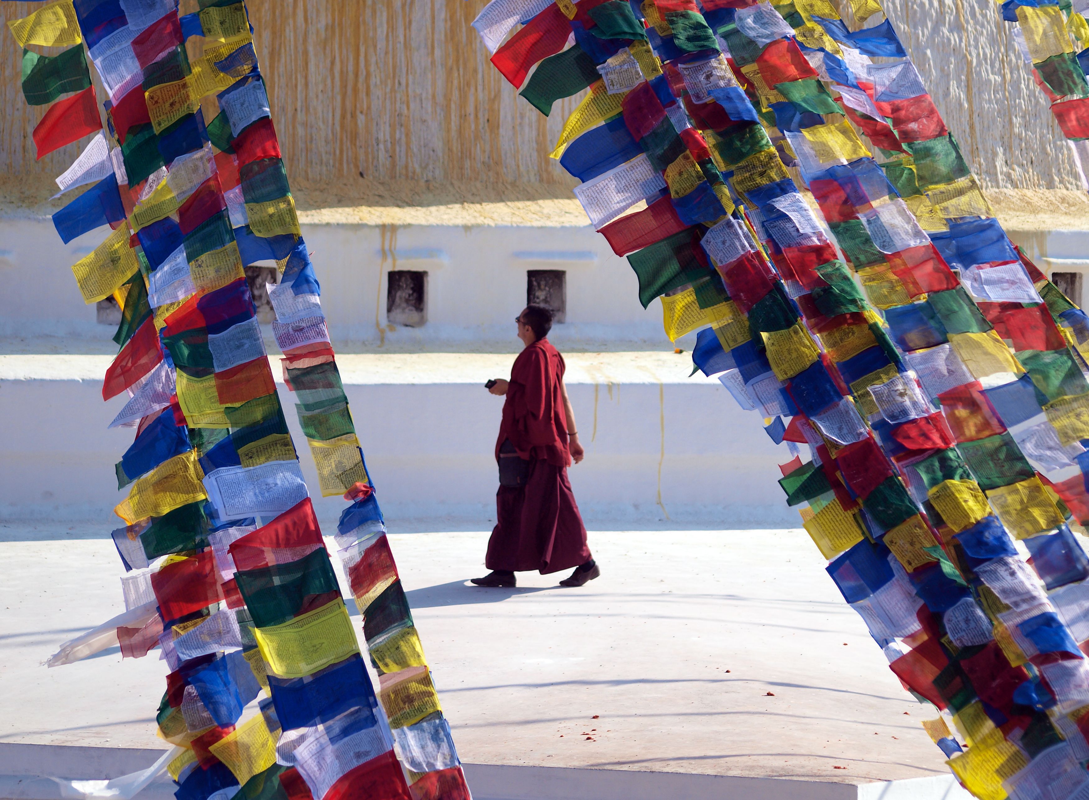 A Buddhist monk walking among prayer flags