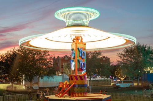 Free Vibrant spinning carousel at a carnival with a stunning sunset backdrop. Stock Photo