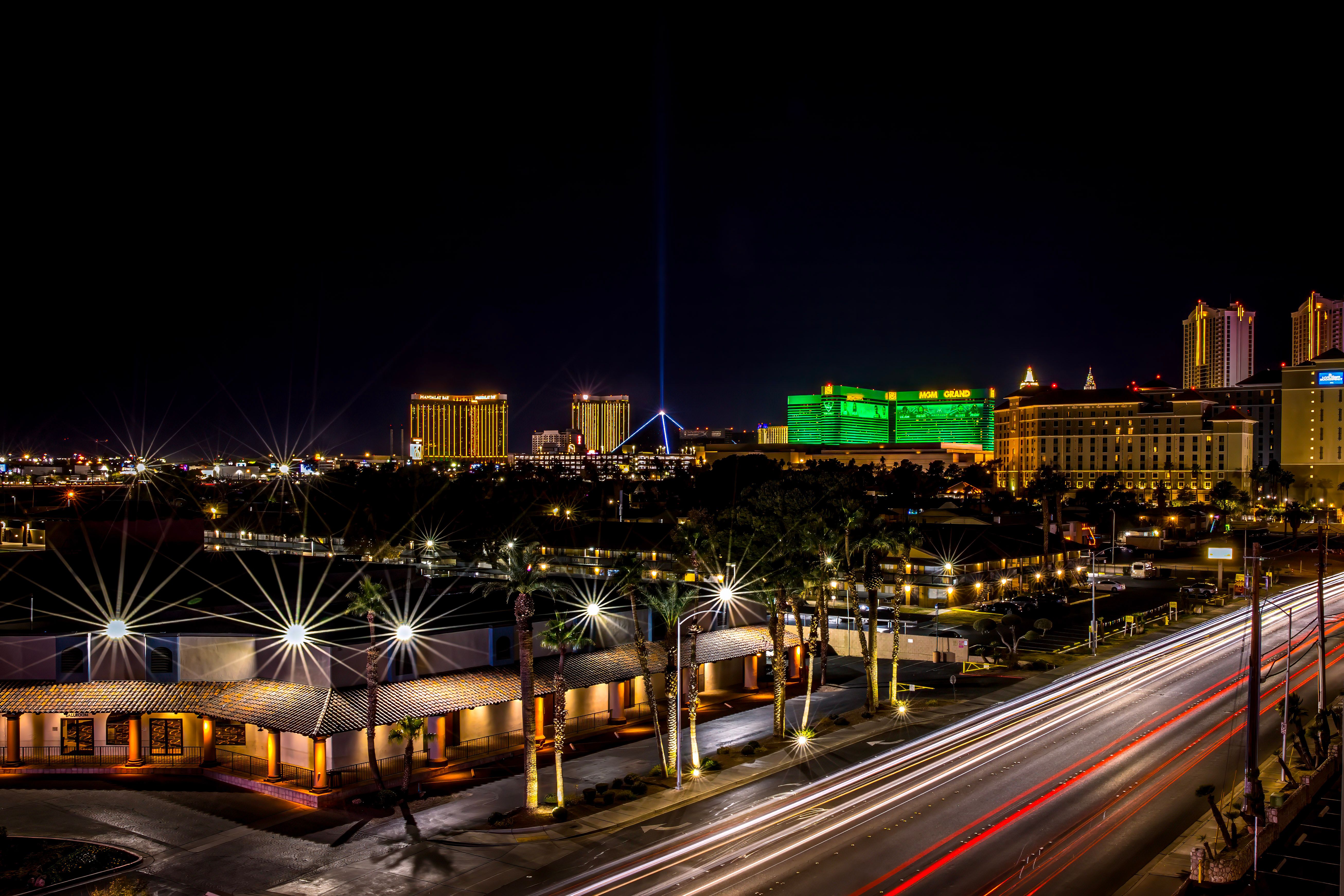 Dynamic night view of Las Vegas Strip with glowing hotels and bustling light trails.