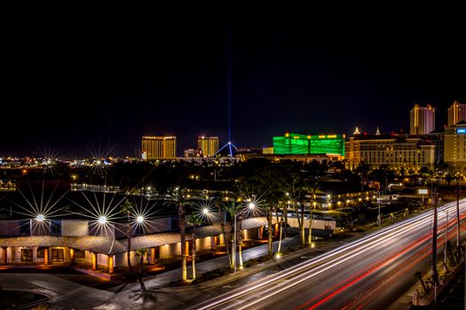 Dynamic night view of Las Vegas Strip with glowing hotels and bustling light trails.