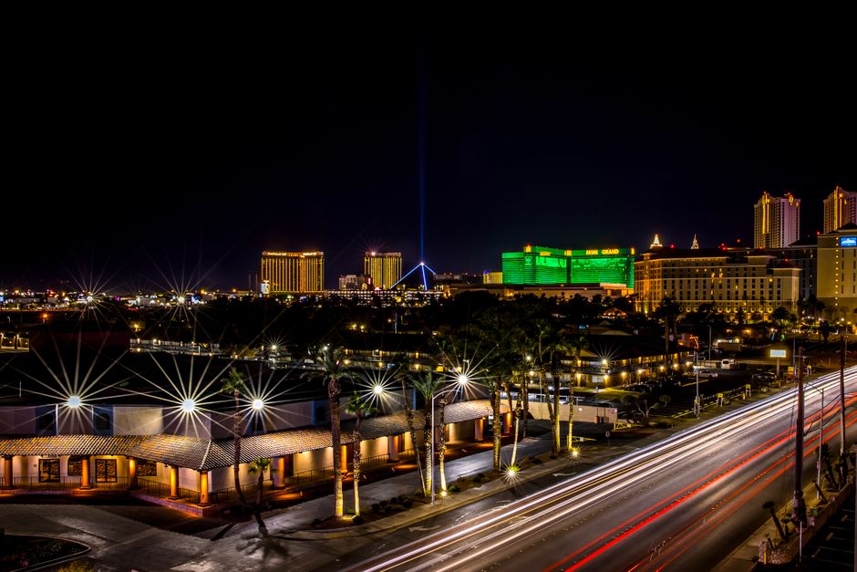 Dynamic night view of Las Vegas Strip with glowing hotels and bustling light trails.