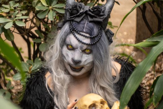 A captivating fantasy character in lush foliage, showcasing elaborate makeup and costume details.