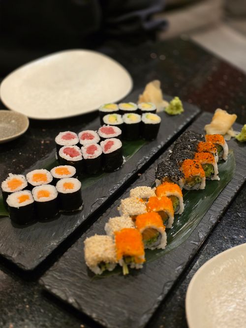 Free Delicious assortment of sushi rolls on elegant slate platters, perfect for a gourmet dining experience. Stock Photo