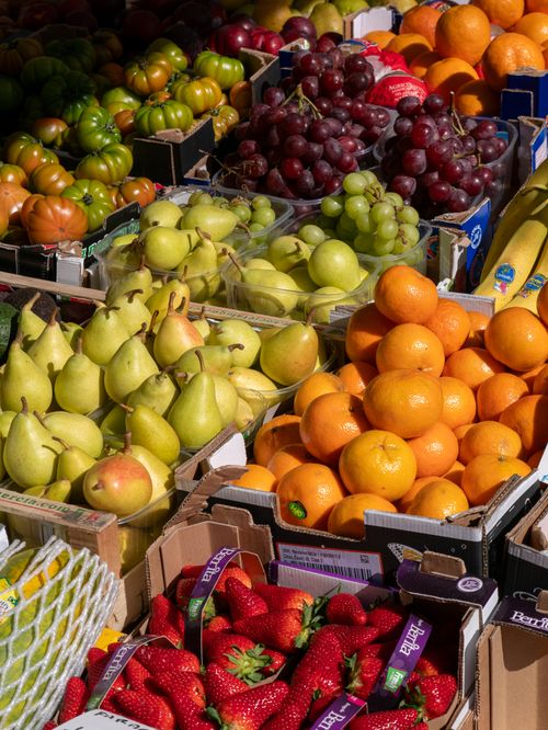 Free A colorful array of fruits including pears, oranges, grapes, and strawberries at a market. Stock Photo