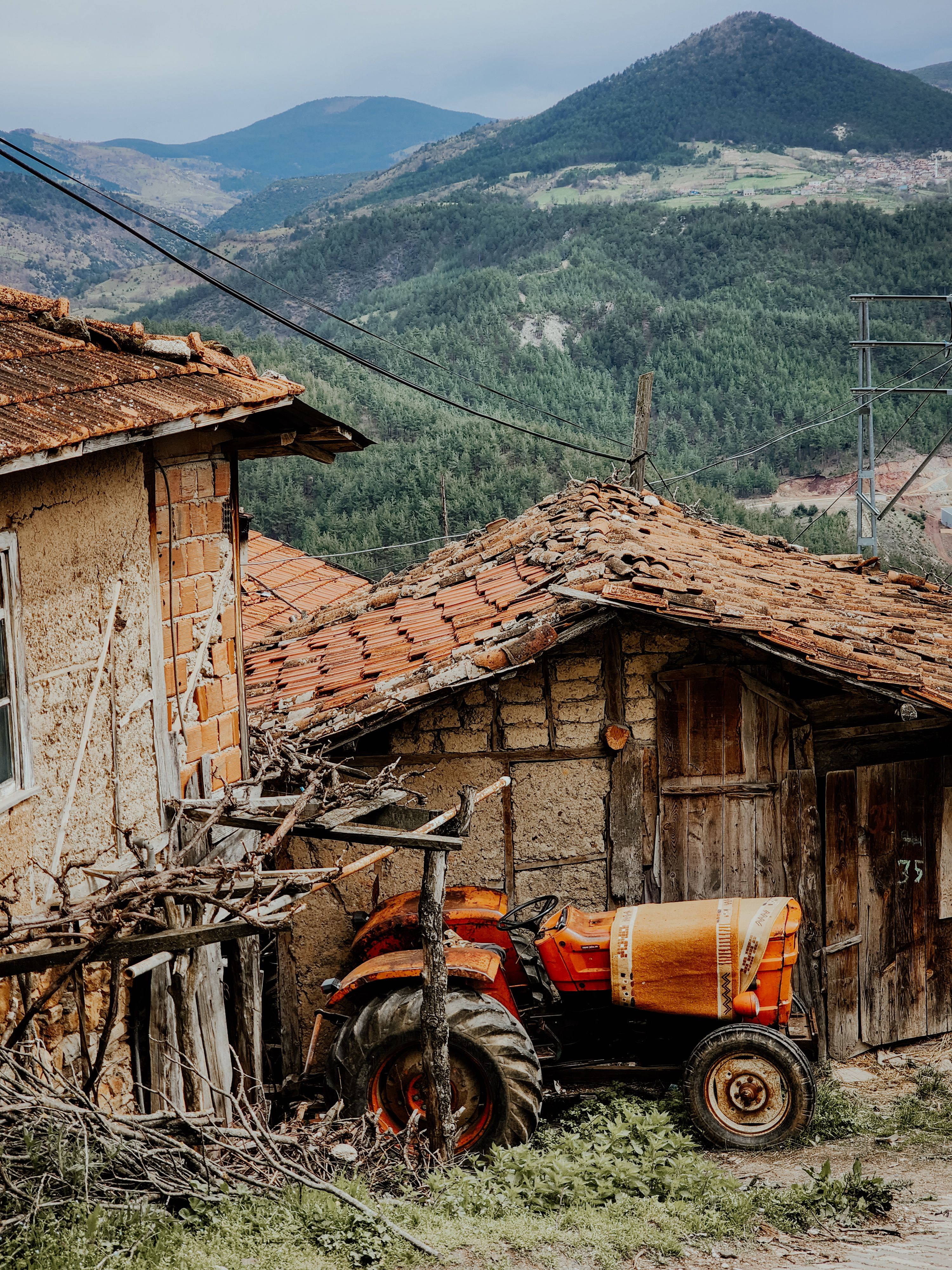 Rural Landscape with Vintage Tractor and Rustic Houses · Free Stock Photo