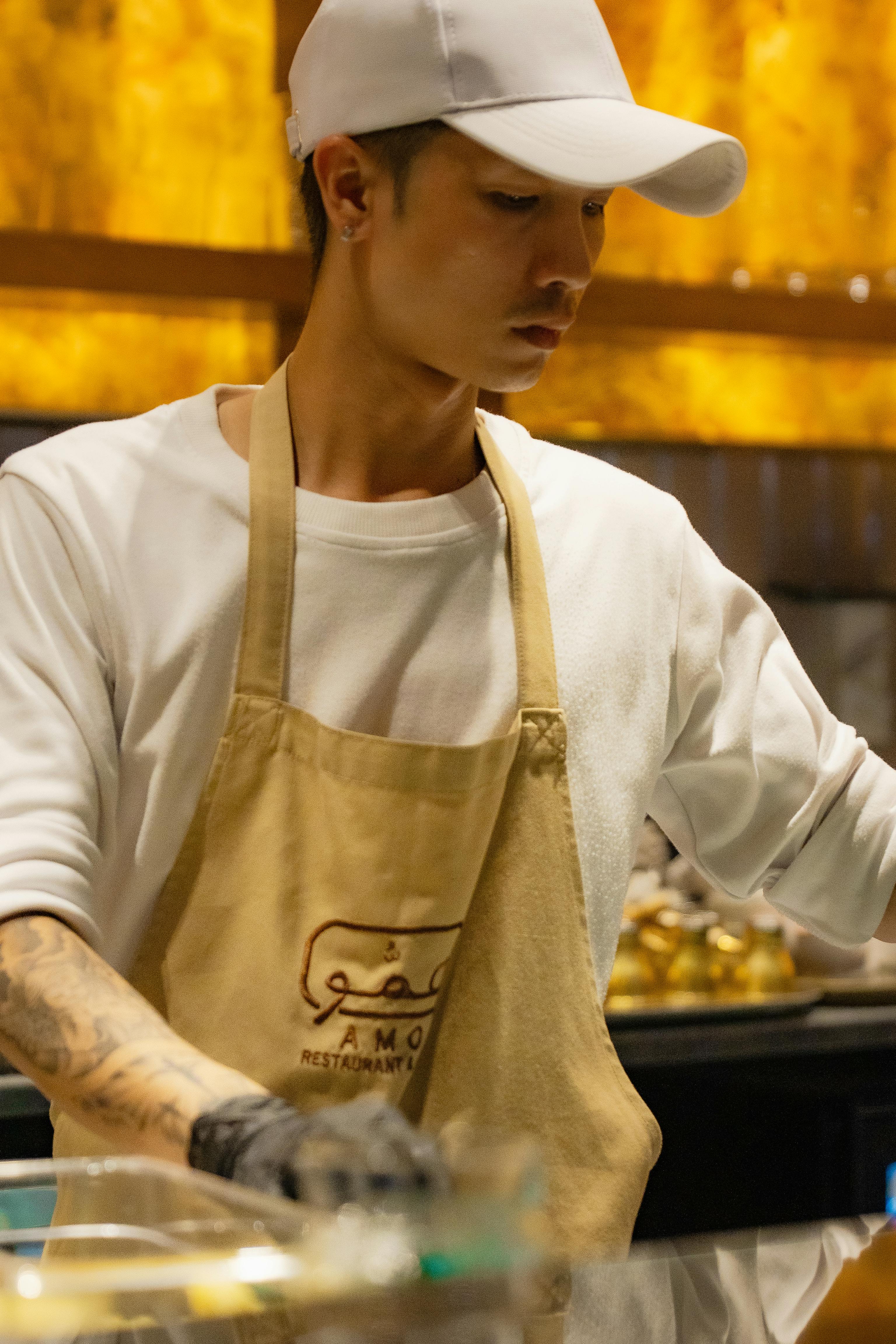 A chef in a modern Dubai restaurant kitchen skillfully preparing a dish with focus.