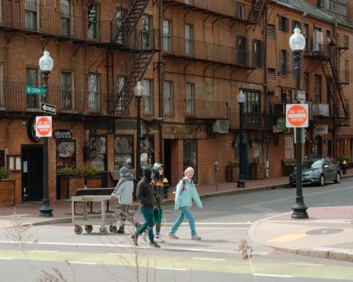Free People cross the street in Boston with historic brick buildings in the background. Stock Photo