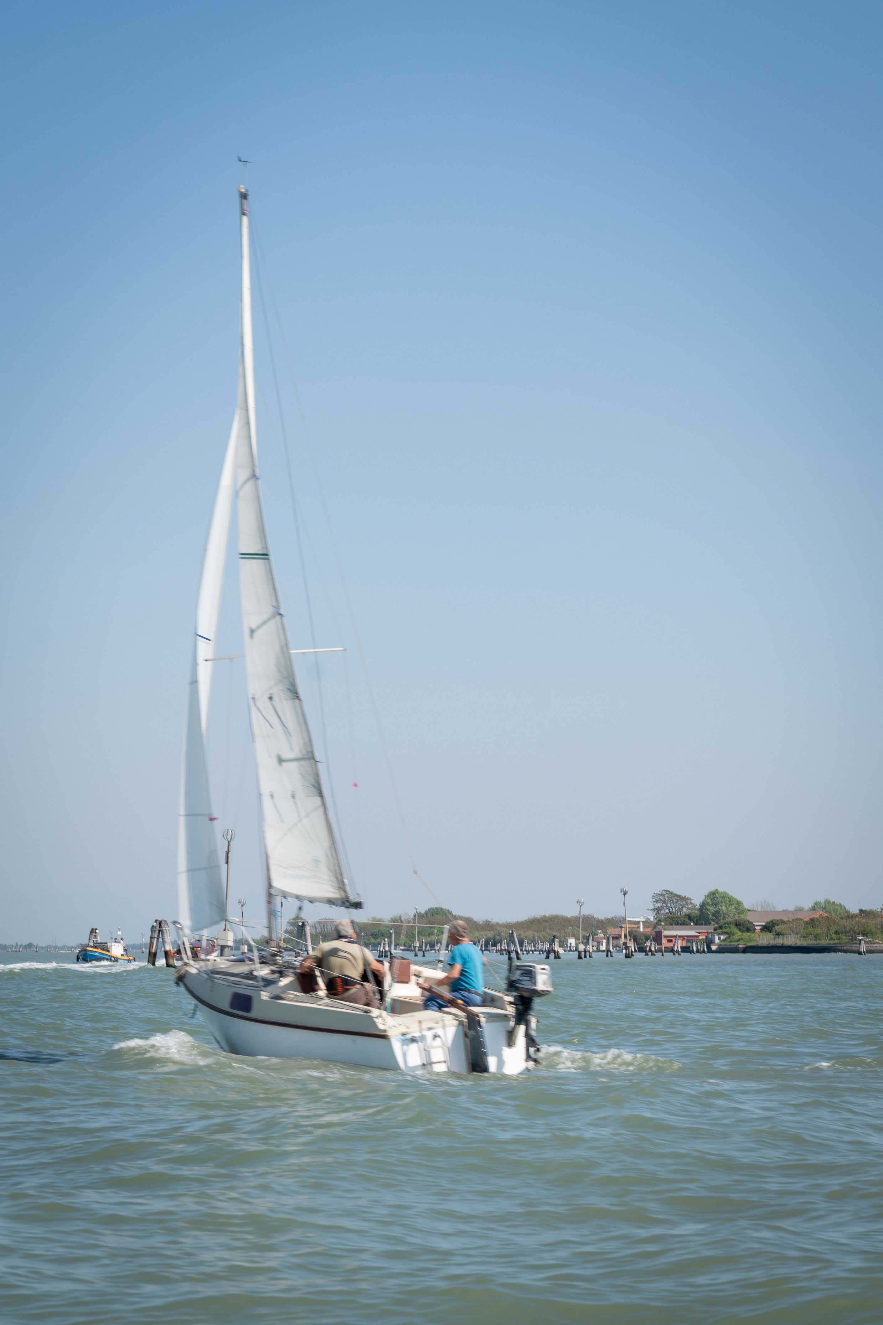 Gratis Una barca a vela in crociera in una giornata di sole nella laguna di Venezia, in Italia, che cattura la serena vita marittima. Foto a disposizione