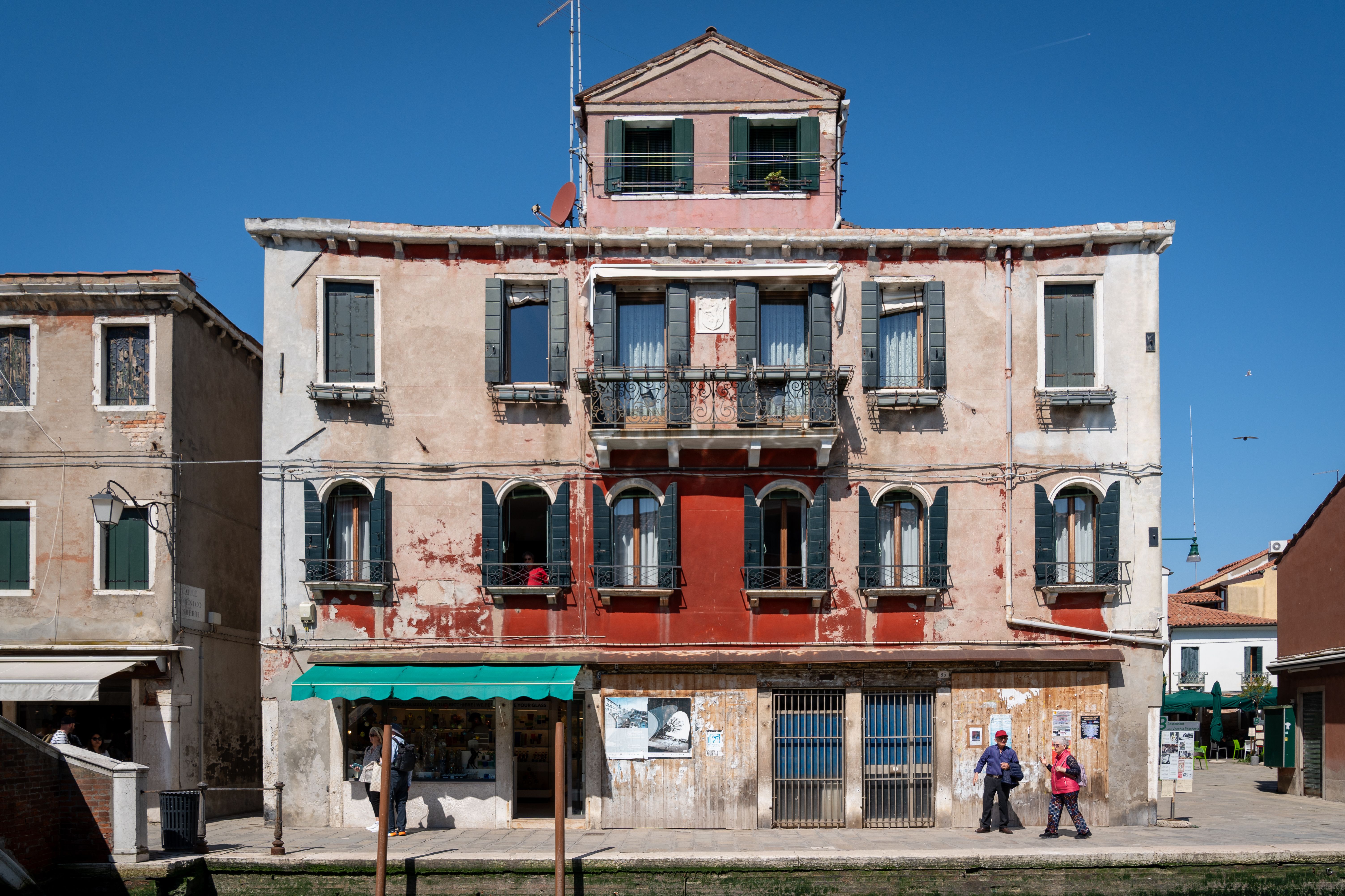 A picturesque building in Murano, Italy, showcasing classic Venetian architecture on a sunny day.