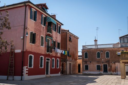 Free Charming street view of colorful buildings in Burano, Venice, showcasing traditional Venetian architecture. Stock Photo